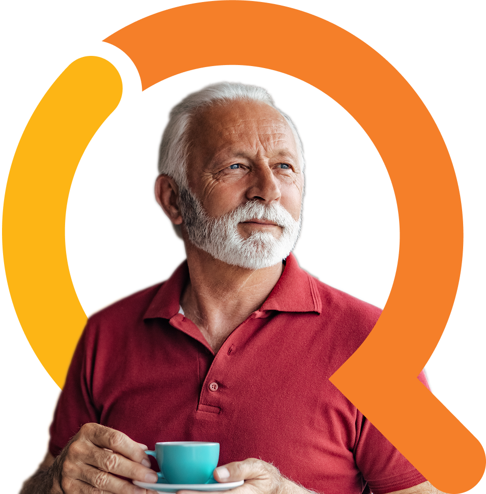 Elderly man with white hair and white beard in a red shirt holding a blue teacup and saucer
